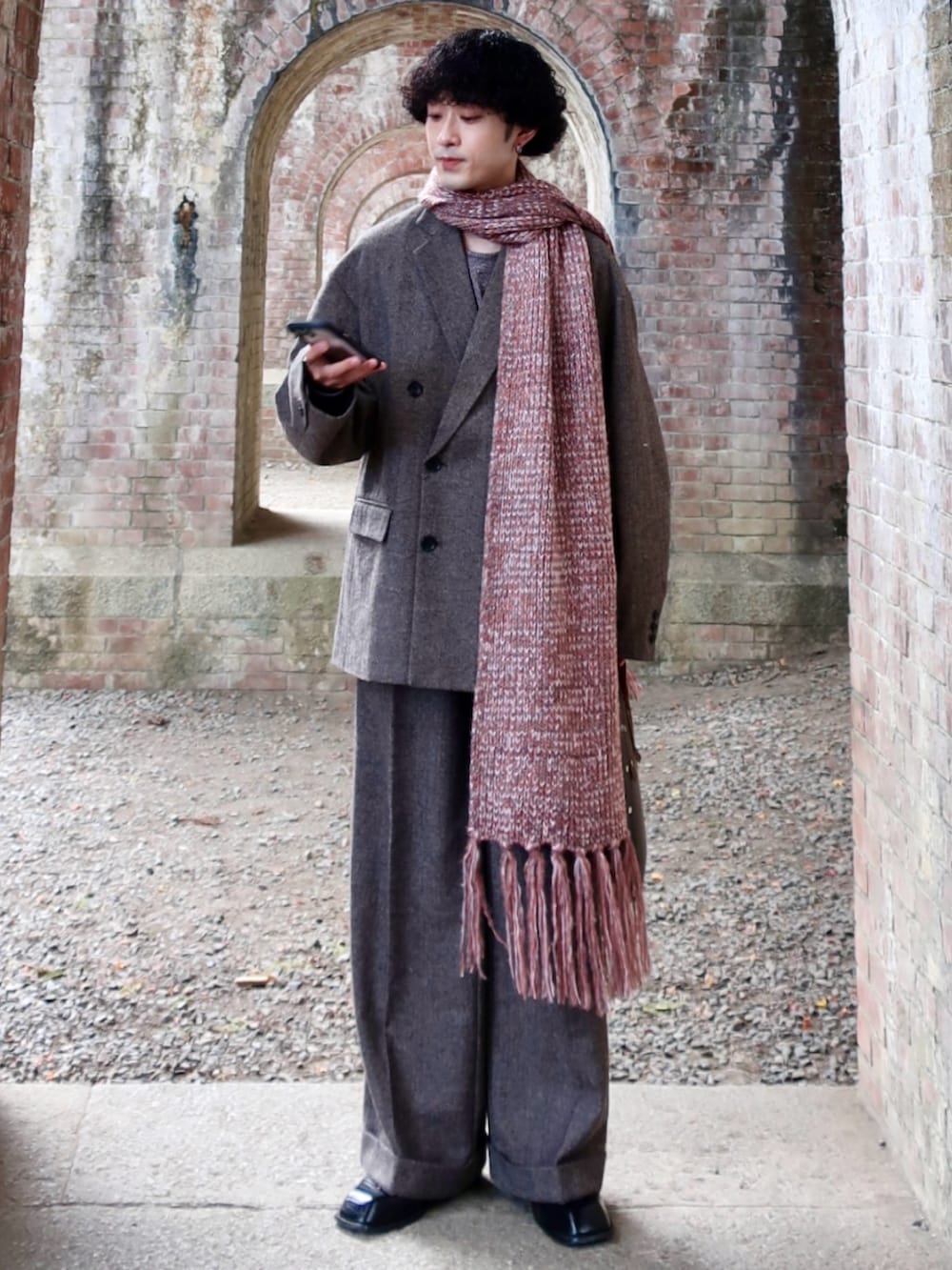 グレー系のテーラードジャケット、グレー系のスラックス、その他のブーツを着用したメンズの冬コーディネートの3枚目の写真