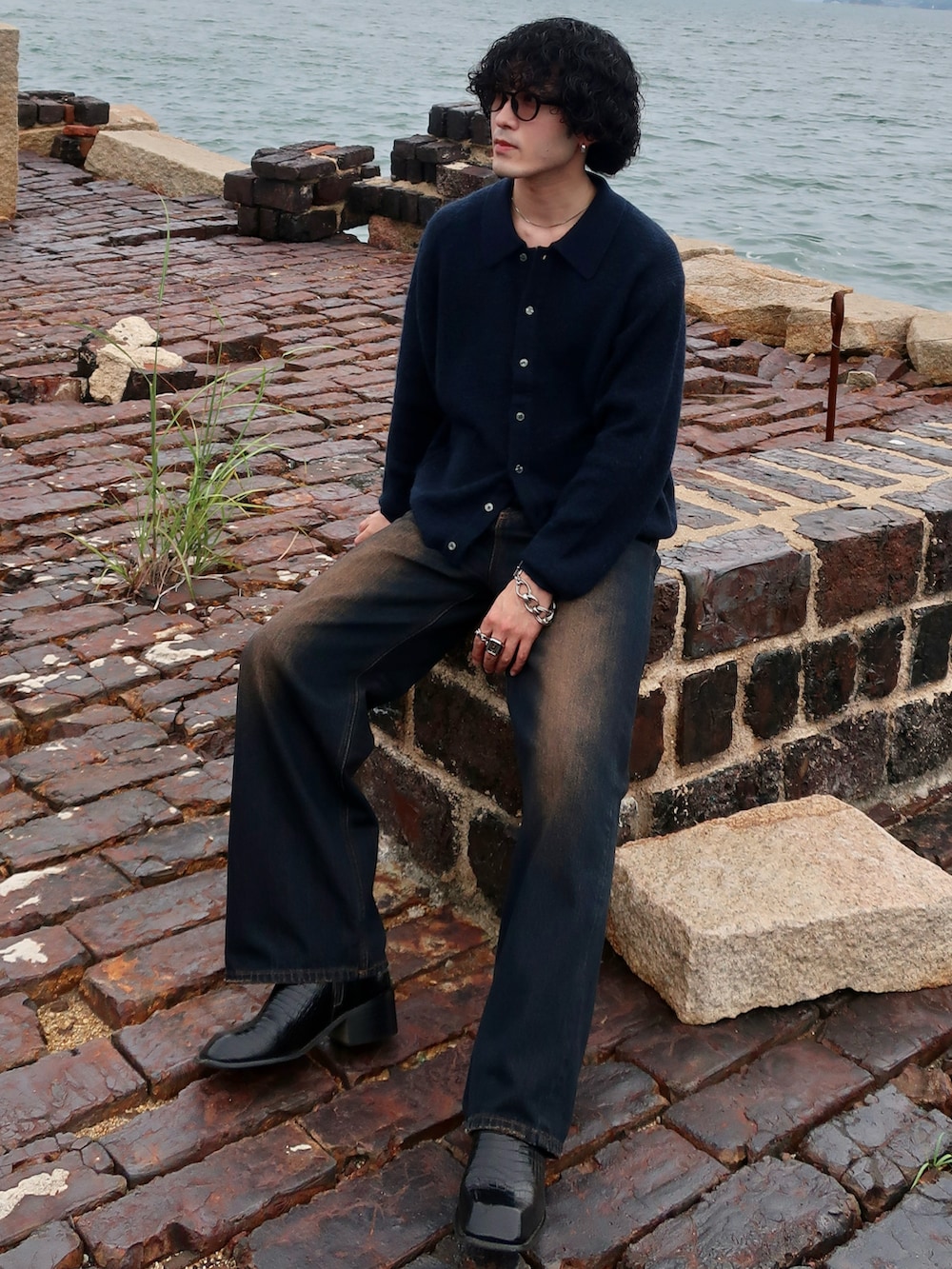 その他のデニムパンツ、ブルー系のニット/セーター、その他のブーツを着用したメンズの秋コーディネートの2枚目の写真