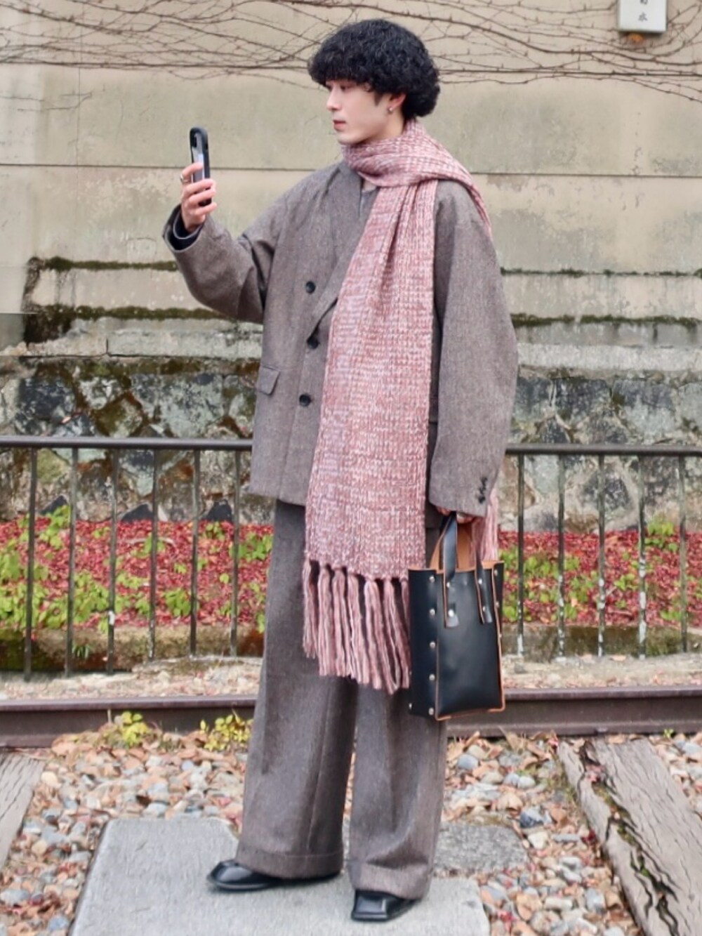 グレー系のテーラードジャケット、グレー系のスラックス、その他のブーツを着用したメンズの冬コーディネートの2枚目の写真