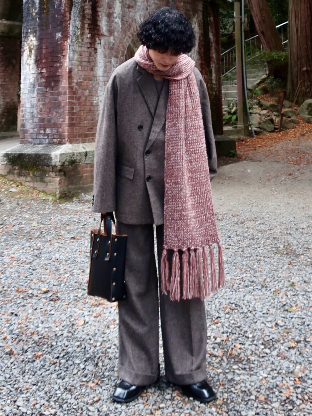 グレー系のテーラードジャケット、グレー系のスラックス、その他のブーツを着用したメンズの冬コーディネートの3枚目の写真