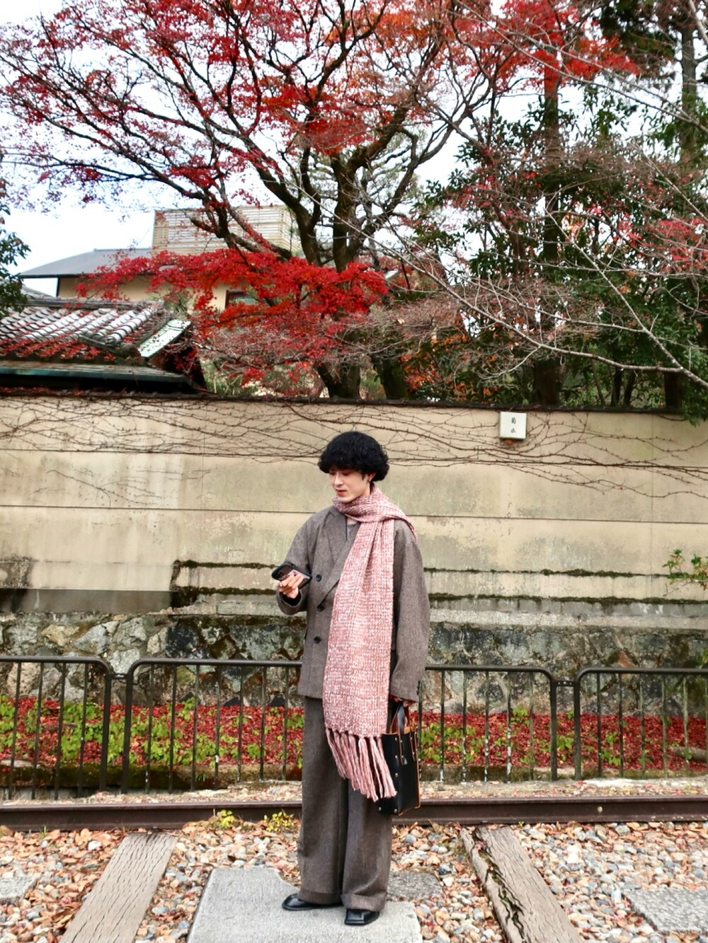 グレー系のテーラードジャケット、グレー系のスラックス、その他のブーツを着用したメンズの冬コーディネートの4枚目の写真