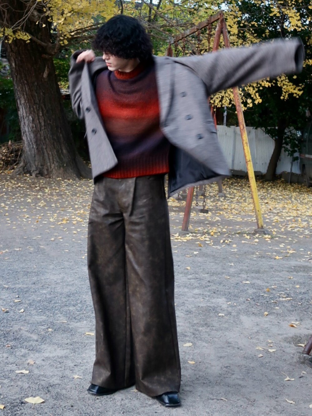 オレンジ系のニット/セーター、ブラウン系のその他パンツ、その他のブーツを着用したメンズの冬コーディネートの2枚目の写真