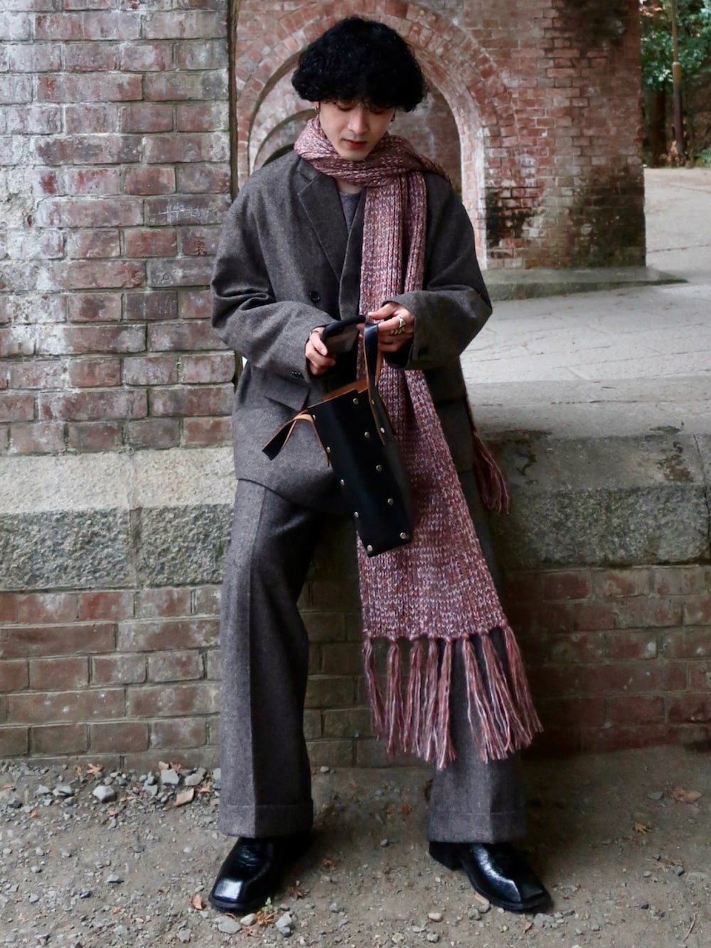 グレー系のテーラードジャケット、グレー系のスラックス、その他のブーツを着用したメンズの冬コーディネートの2枚目の写真