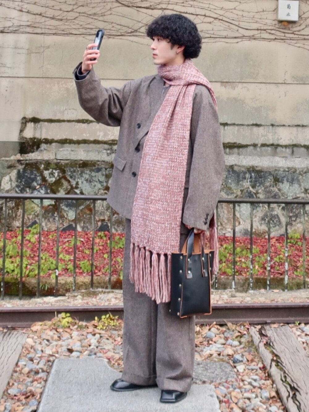 グレー系のテーラードジャケット、グレー系のスラックス、その他のブーツを着用したメンズの冬コーディネートの3枚目の写真