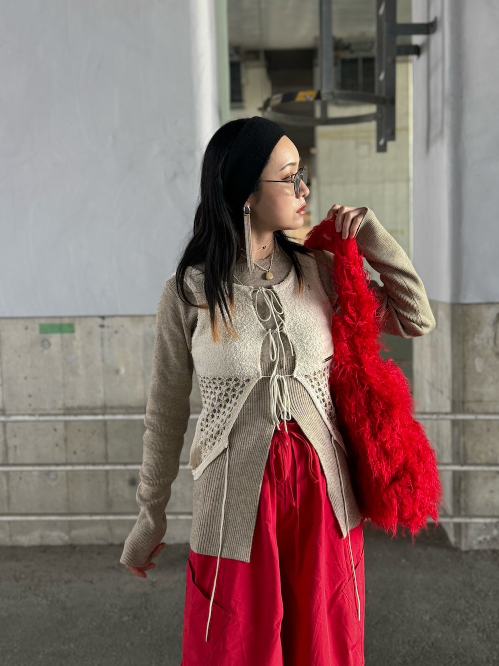 ホワイト系のニット/セーター、ホワイト系のタンクトップ、レッド系のトートバッグを着用したレディースの冬コーディネートの2枚目の写真