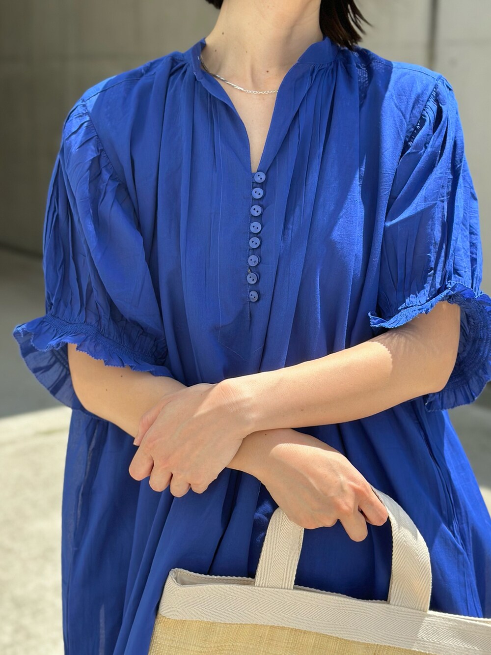 ブルー系のワンピース、ブラック系のトートバッグ、ブラック系のサンダルを着用したレディースの春コーディネートの4枚目の写真