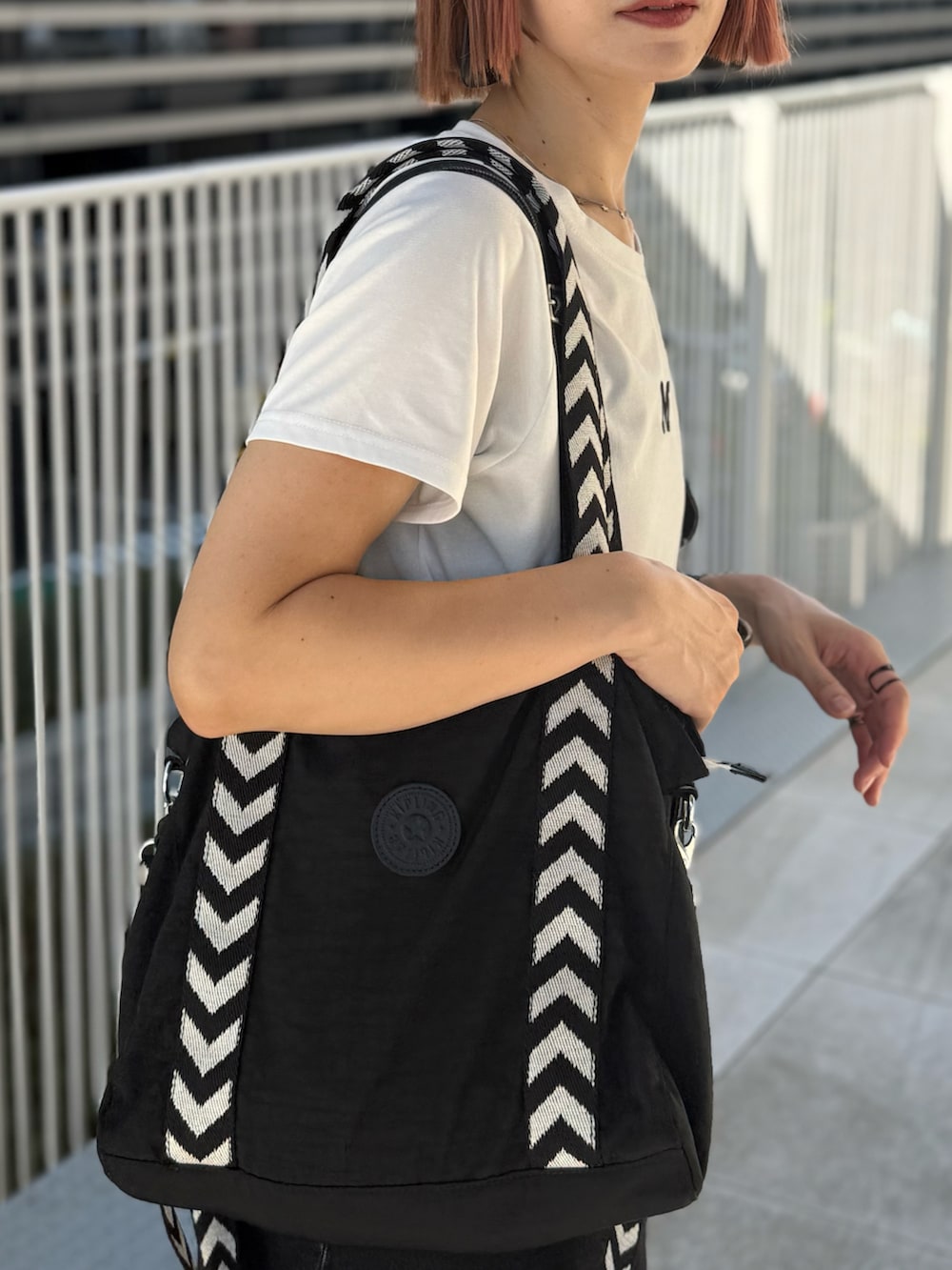 ホワイト系のTシャツ/カットソー、ホワイト系のスニーカー、ブラック系のバッグを着用したレディースの夏コーディネートの4枚目の写真