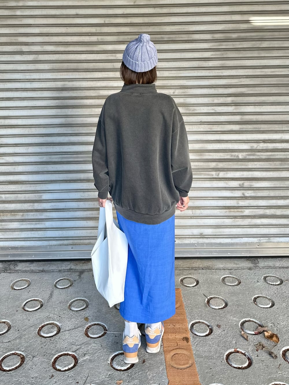 グレー系のスウェット、ブルー系のスニーカー、ホワイト系のトートバッグを着用したレディースの春コーディネートの3枚目の写真