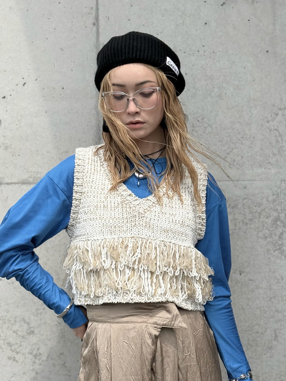 ブラック系のハンドバッグ、ブルー系のTシャツ/カットソー、ホワイト系のベストを着用したレディースの春コーディネートの2枚目の写真