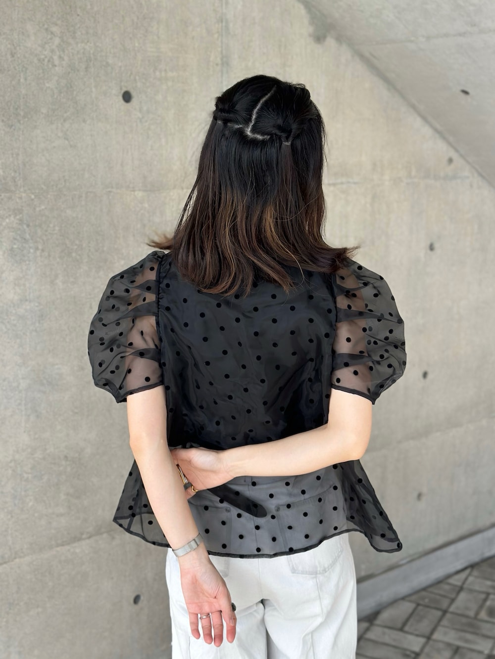ブラック系のチューブトップ、ブルー系のデニムパンツ、ブラック系のサンダルを着用したレディースの春コーディネートの5枚目の写真
