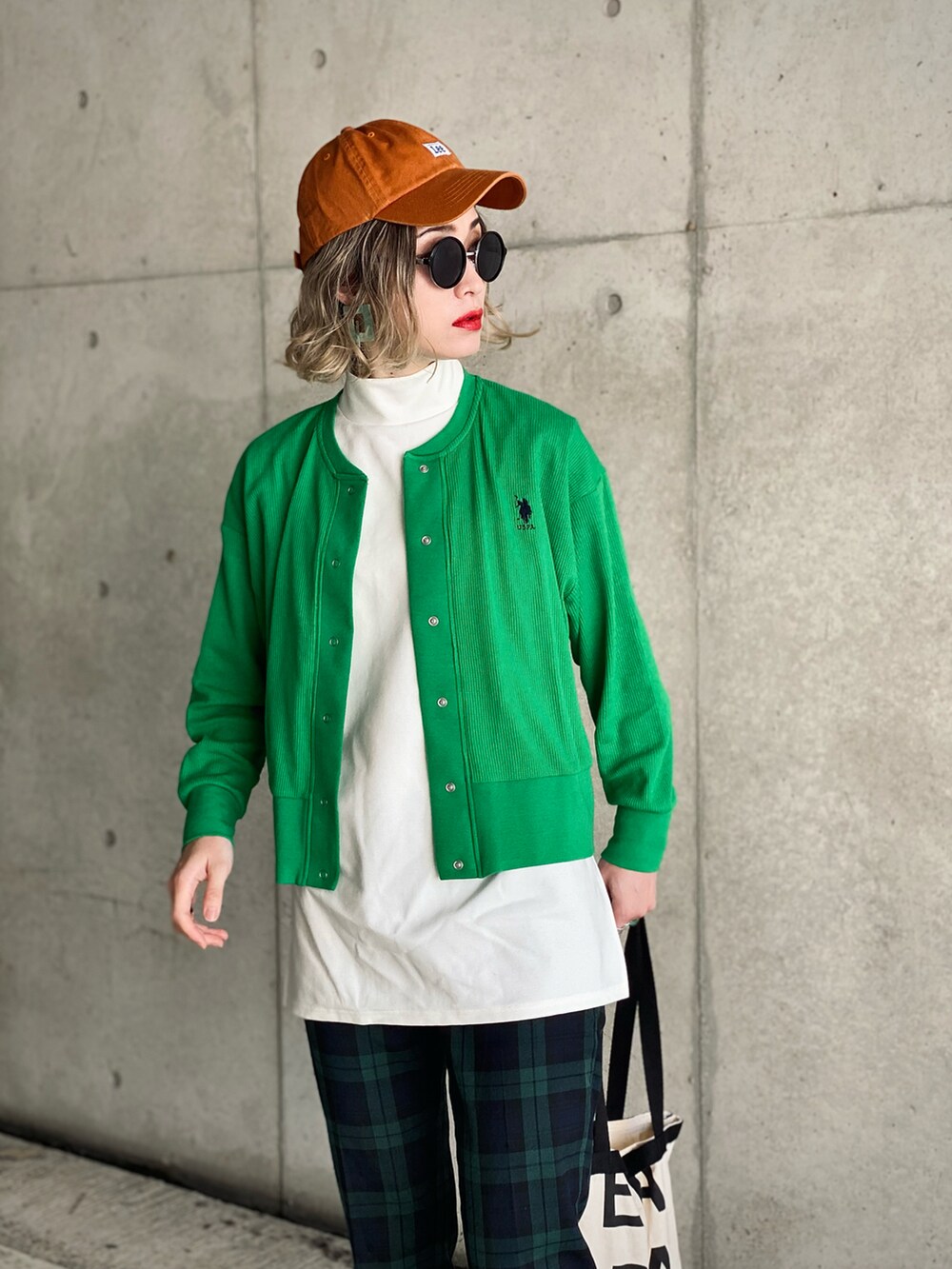 グリーン系のカーディガン/ボレロ、ブラック系のトップス、ブラック系のTシャツ/カットソーを着用したレディースの春コーディネートの2枚目の写真