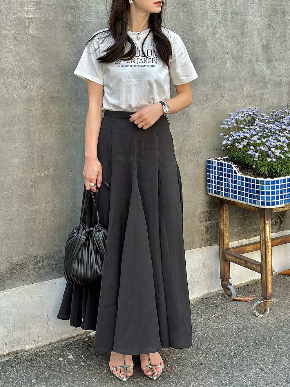 ホワイト系のTシャツ/カットソー、シルバー系のサンダル、ブラック系のスカートを着用したレディースの春コーディネートの4枚目の写真