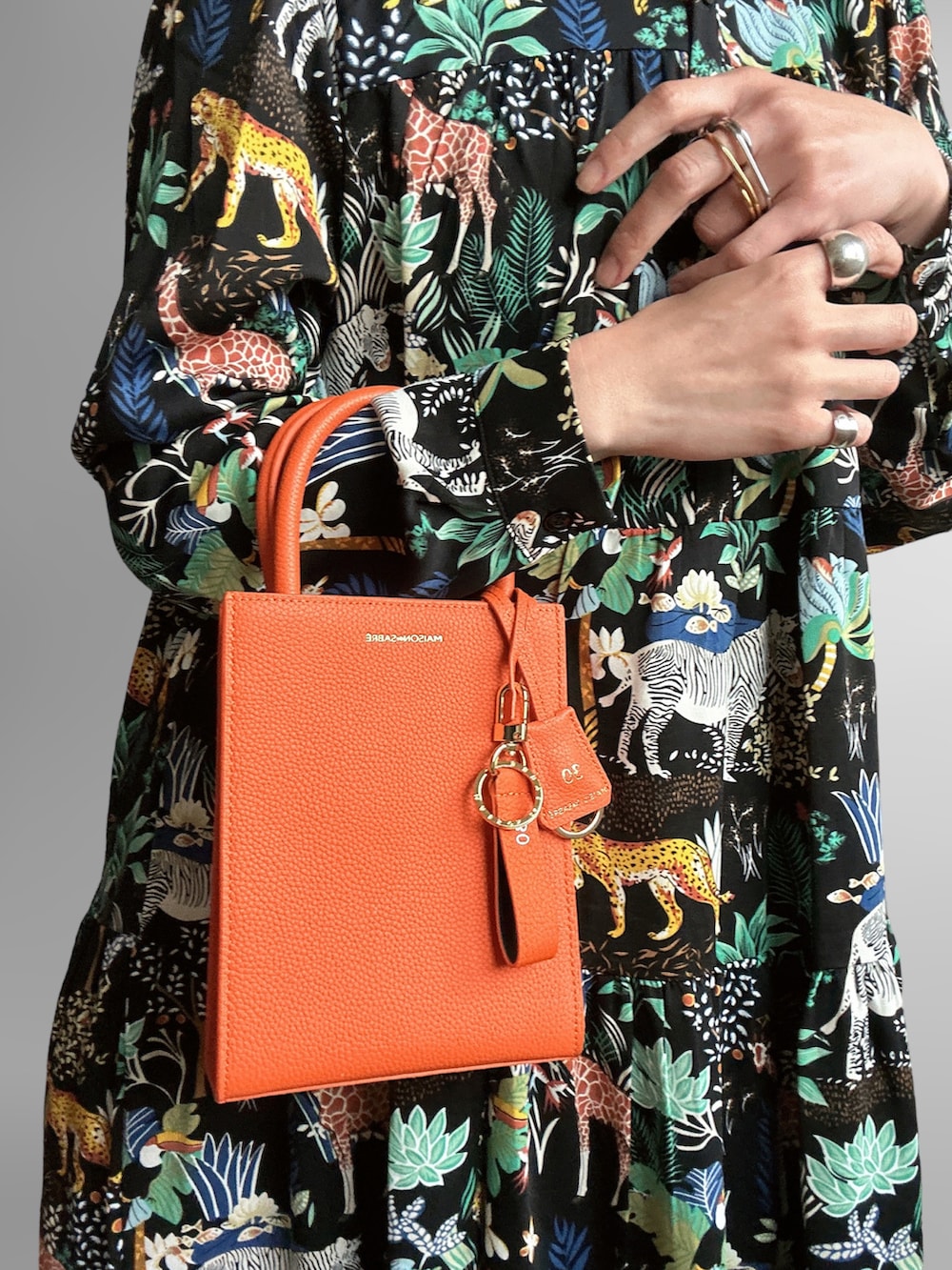 ブラック系のワンピース、シルバー系のサンダル、オレンジ系のトートバッグを着用したレディースの春コーディネートの3枚目の写真