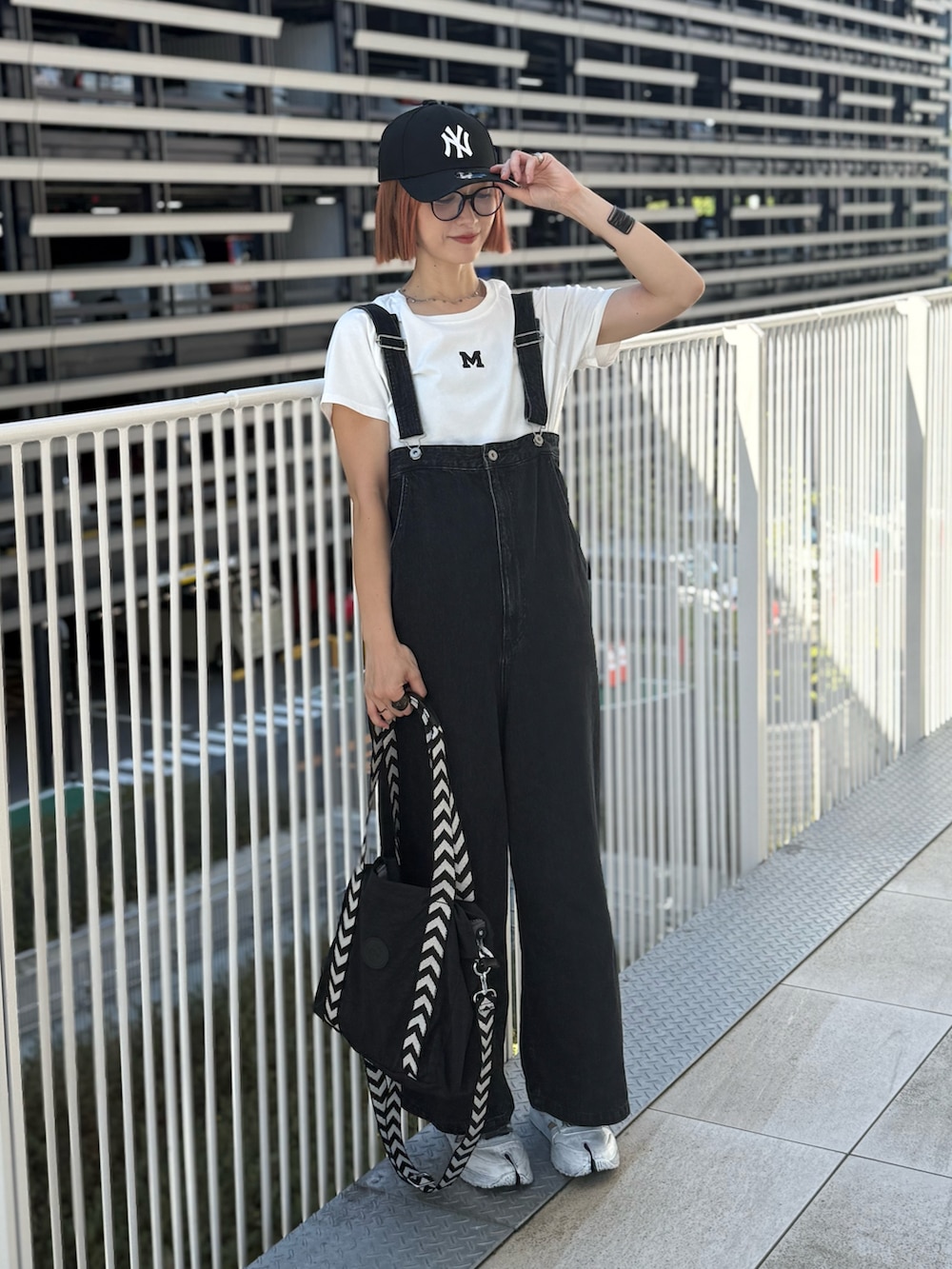 ホワイト系のTシャツ/カットソー、ホワイト系のスニーカー、ブラック系のバッグを着用したレディースの夏コーディネートの5枚目の写真