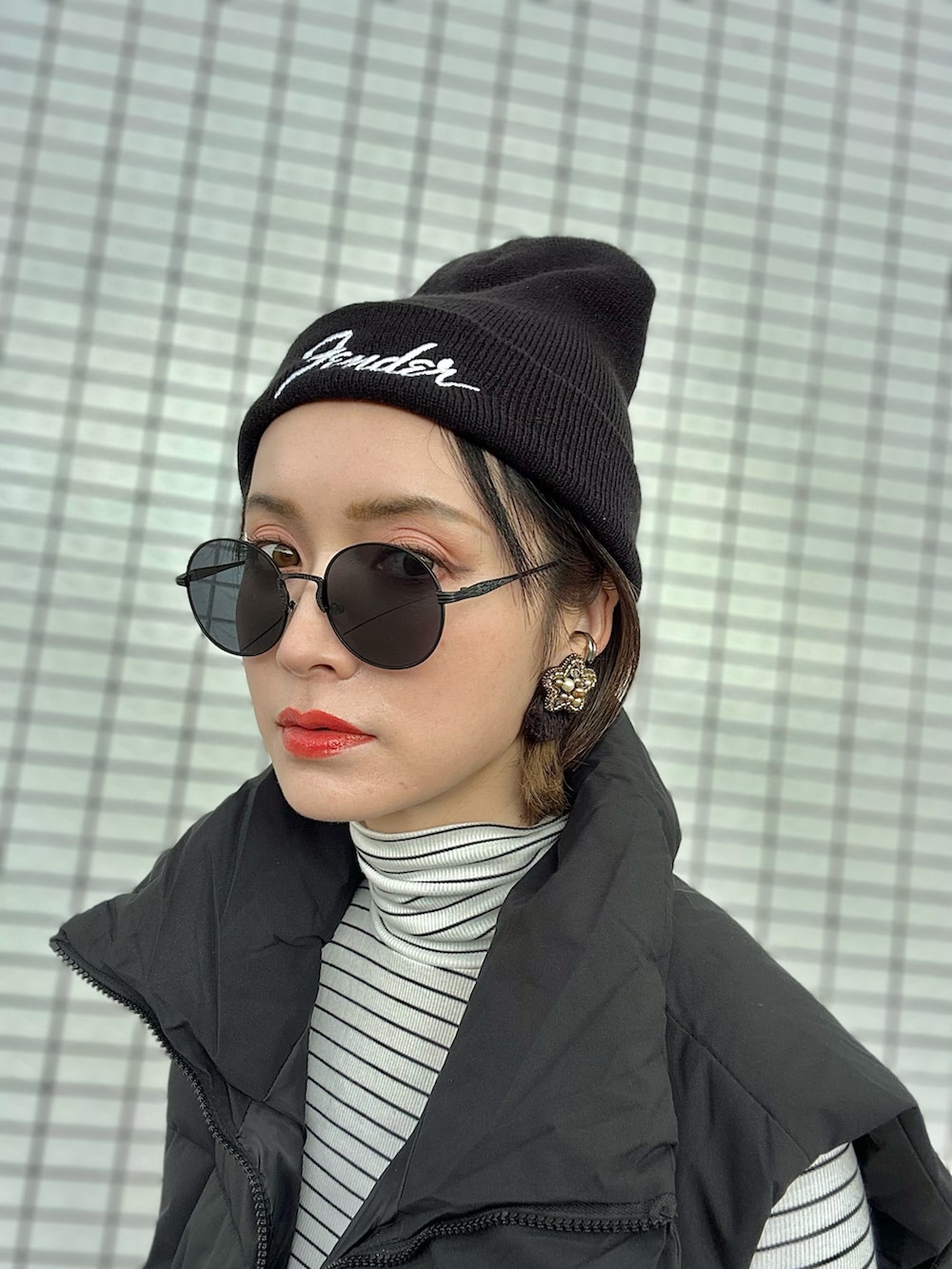 ブラック系のダウンベスト、イエロー系のスカート、ホワイト系のスニーカーを着用したレディースの冬コーディネートの3枚目の写真