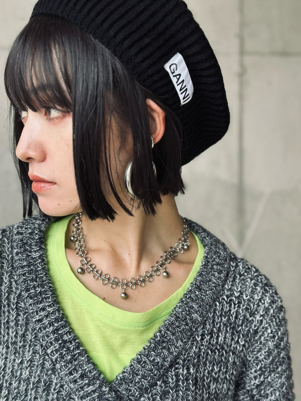 ブラック系のブーツ、ブラック系のカーディガン/ボレロ、シルバー系のハンドバッグを着用したレディースの秋コーディネートの4枚目の写真