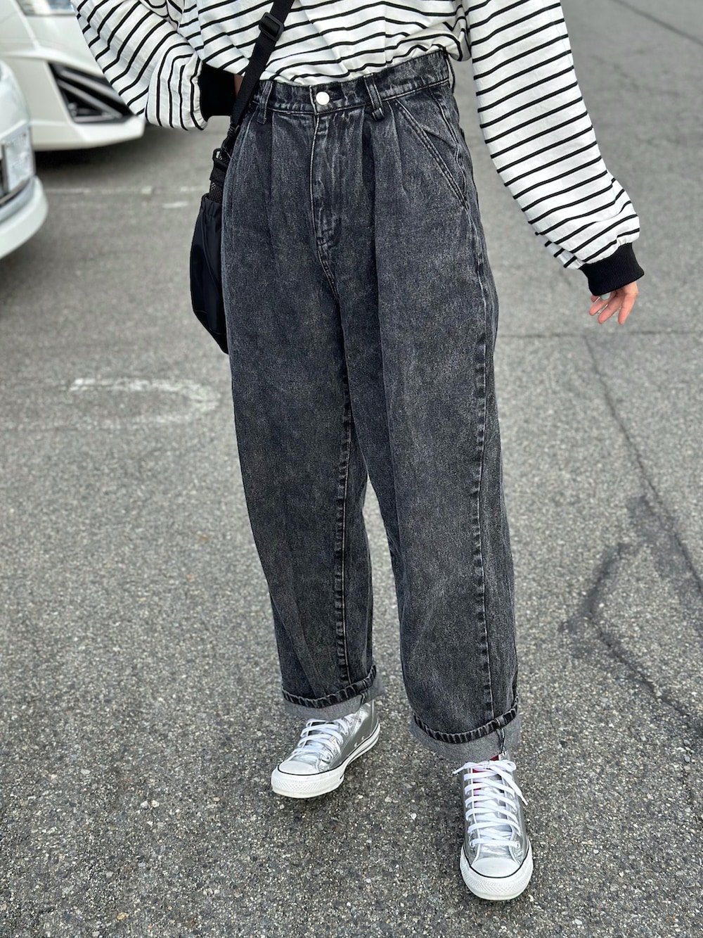 ブラック系のデニムパンツ、ブラック系のショルダーバッグ、ブラック系のTシャツ/カットソーを着用したレディースの春コーディネートの3枚目の写真