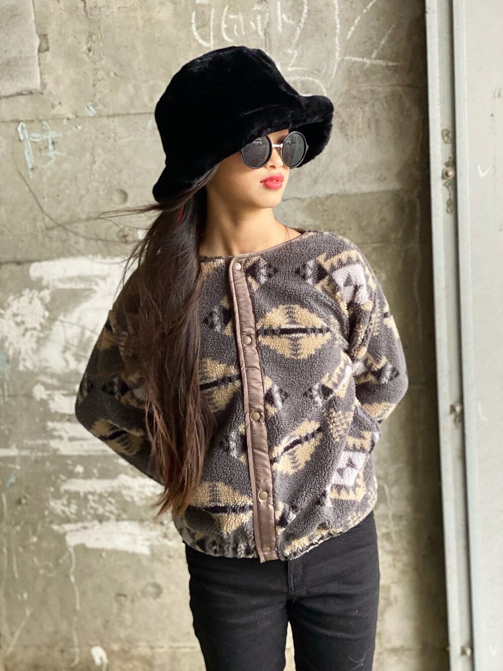 ブラック系のデニムパンツ、ブラック系のショルダーバッグ、ホワイト系のブーツを着用したレディースの秋コーディネートの3枚目の写真