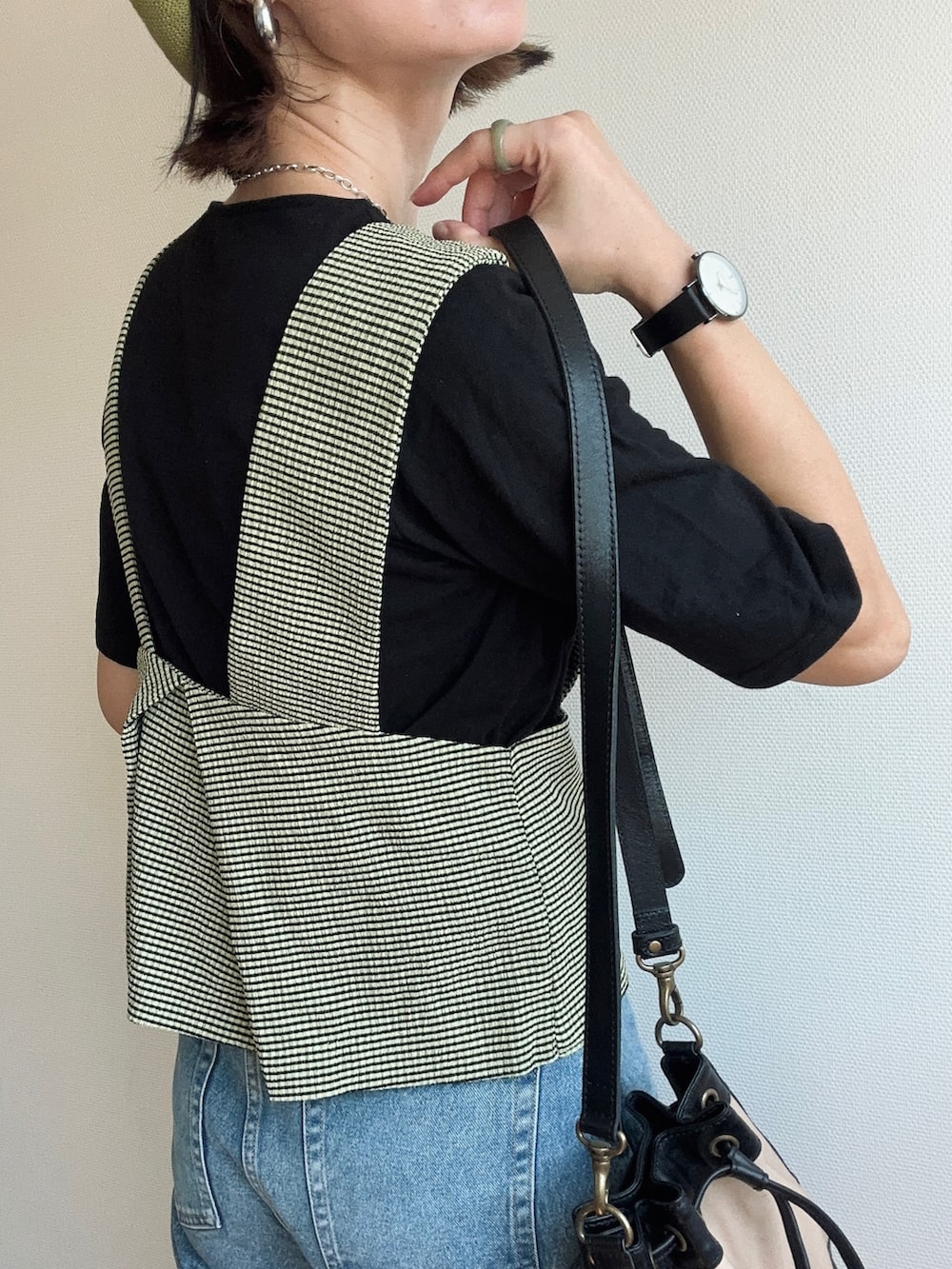 グリーン系のベスト、ブラック系のTシャツ/カットソー、ブルー系のデニムパンツを着用したレディースの夏コーディネートの3枚目の写真