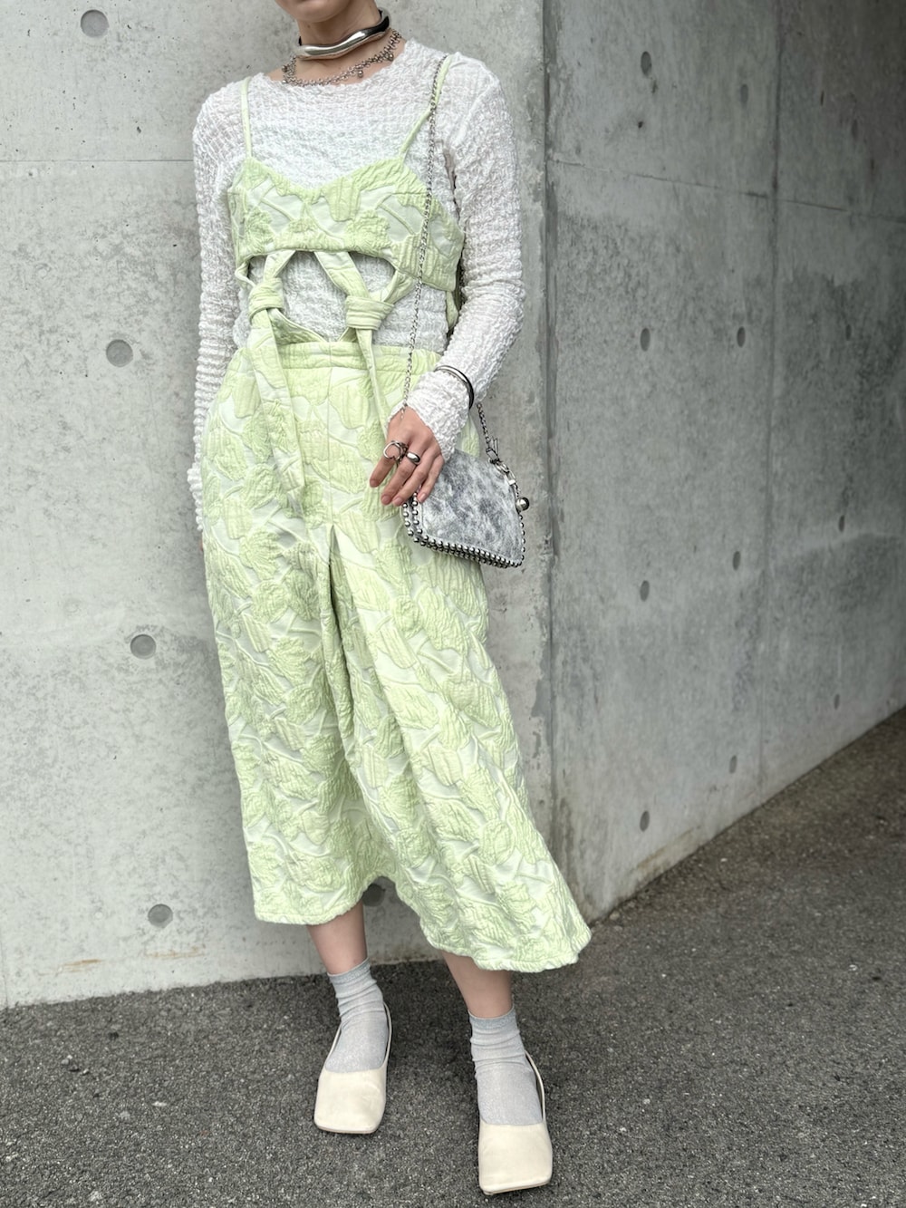 グリーン系のワンピース、ホワイト系のTシャツ/カットソー、シルバー系のピアス(両耳用)を着用したレディースの春コーディネートの2枚目の写真