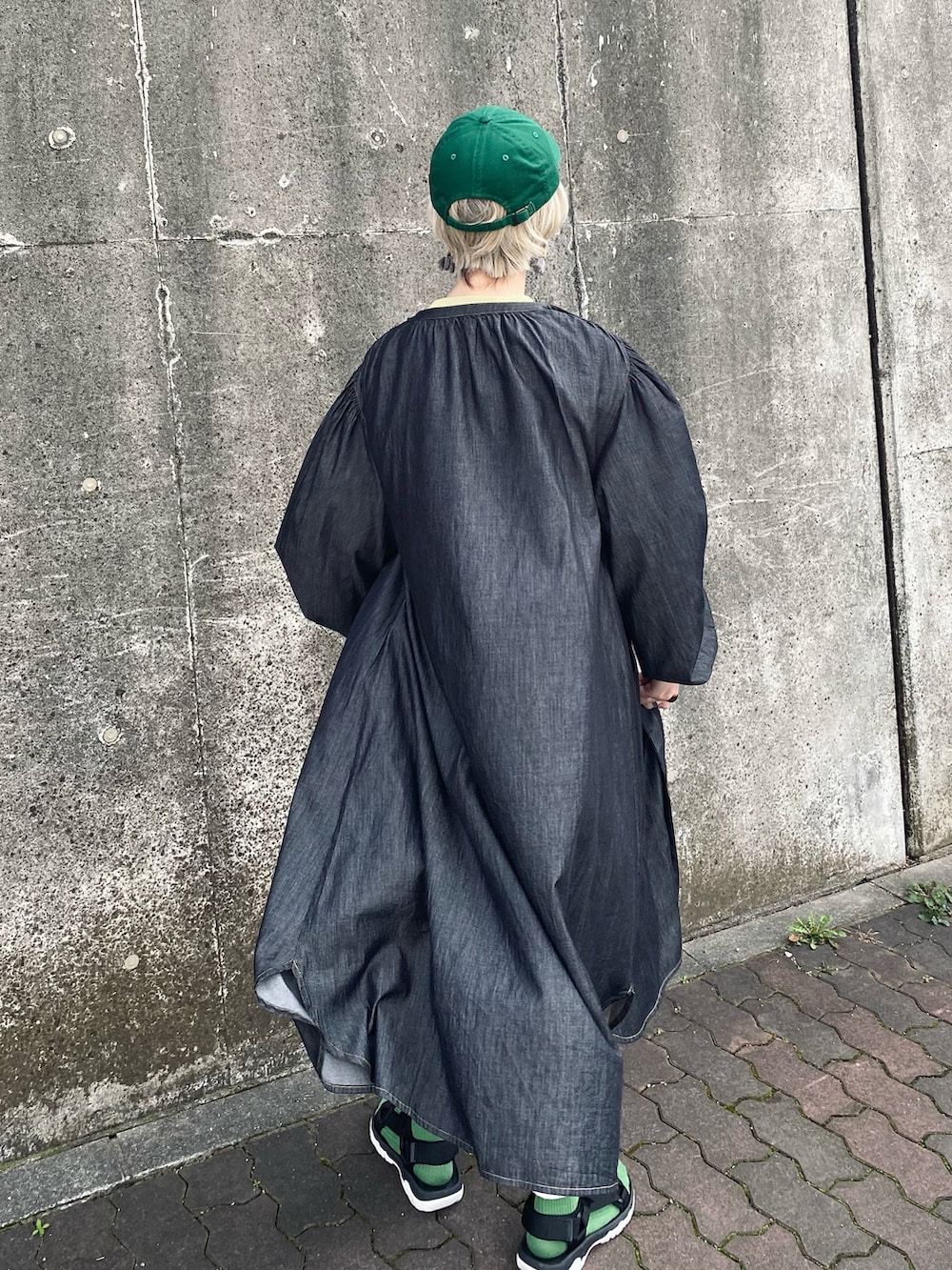 グリーン系のスウェット、ホワイト系のデニムパンツ、ブラック系のサンダルを着用したレディースの春コーディネートの5枚目の写真