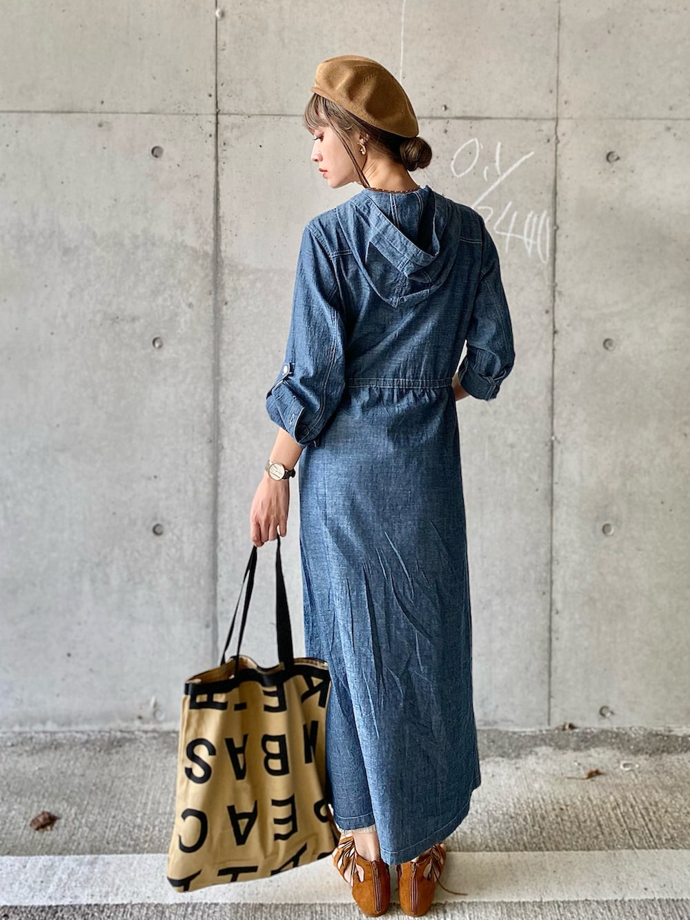 ブルー系のシャツワンピース、ベージュ系のトートバッグ、ブラウン系のサンダルを着用したレディースの春コーディネートの4枚目の写真