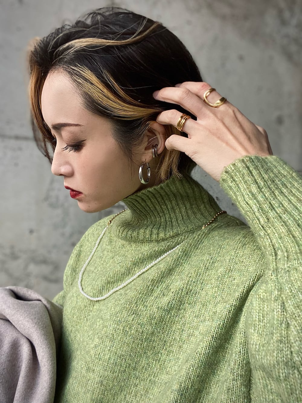 ベージュ系のその他アウター、グリーン系のニット/セーター、ホワイト系のブーツを着用したレディースの冬コーディネートの3枚目の写真