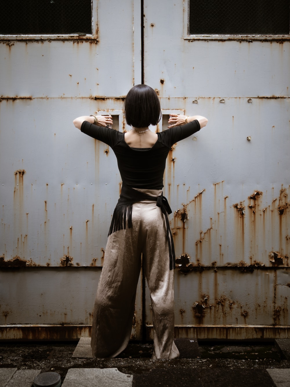 ベージュ系のスラックス、ブラック系のパンプス、ブラック系のウィッグを着用したレディースの夏コーディネートの4枚目の写真