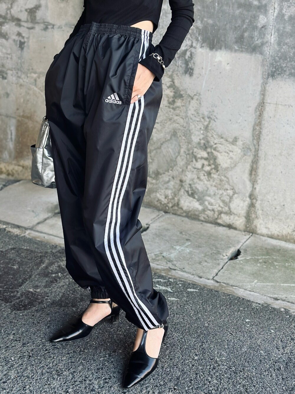 シルバー系のハンドバッグ、ブラック系のTシャツ/カットソー、ブラック系のその他パンツを着用したレディースの秋コーディネートの5枚目の写真