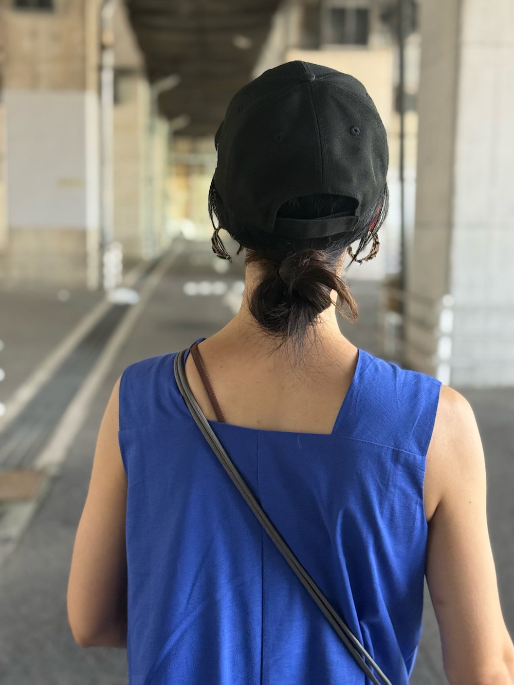 ブルー系のワンピース、ベージュ系のスニーカー、ブラック系のキャップを着用したレディースの夏コーディネートの4枚目の写真