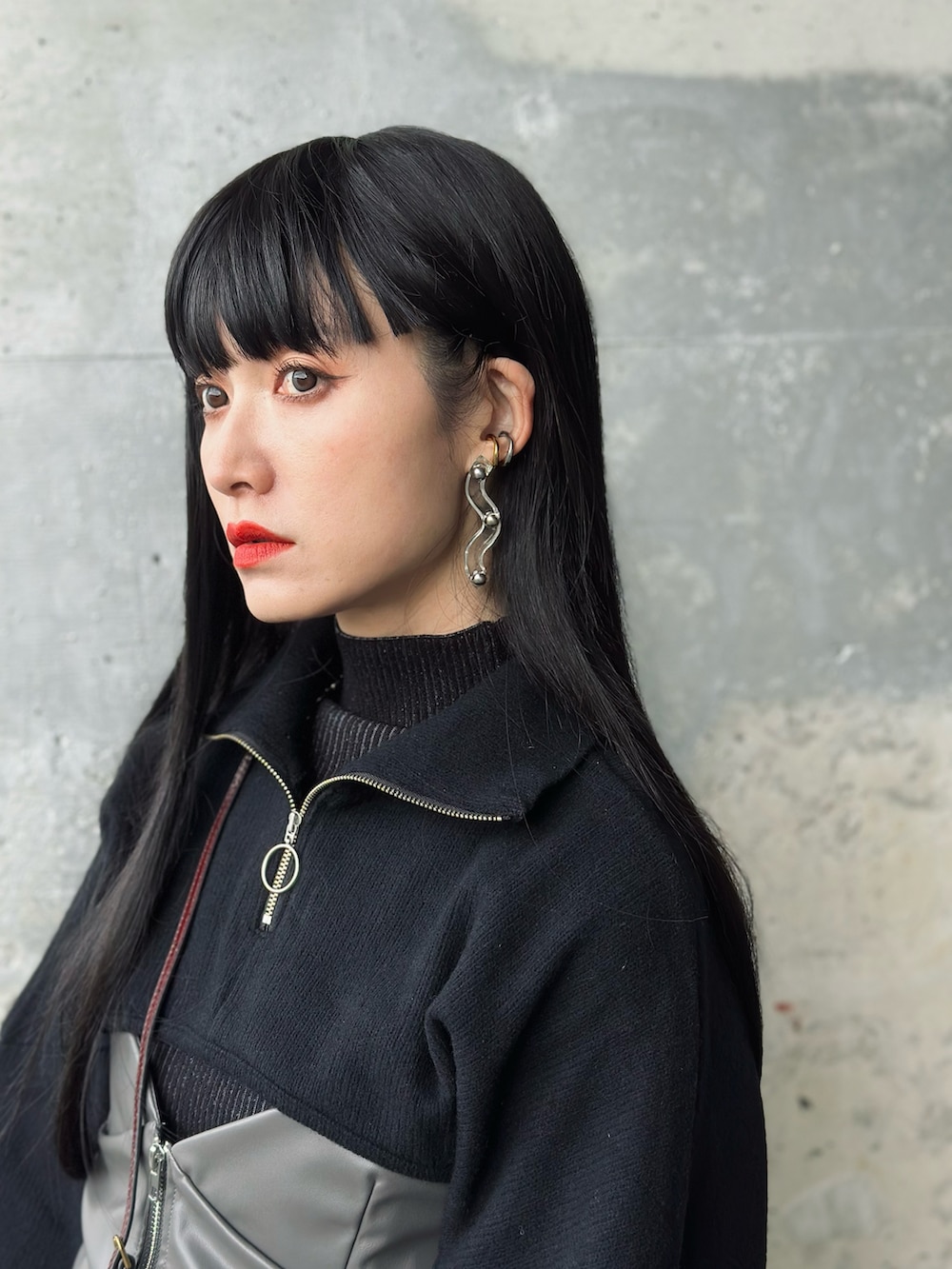 その他のスカート、レッド系のショルダーバッグ、ブラック系のニット/セーターを着用したレディースの冬コーディネートの2枚目の写真