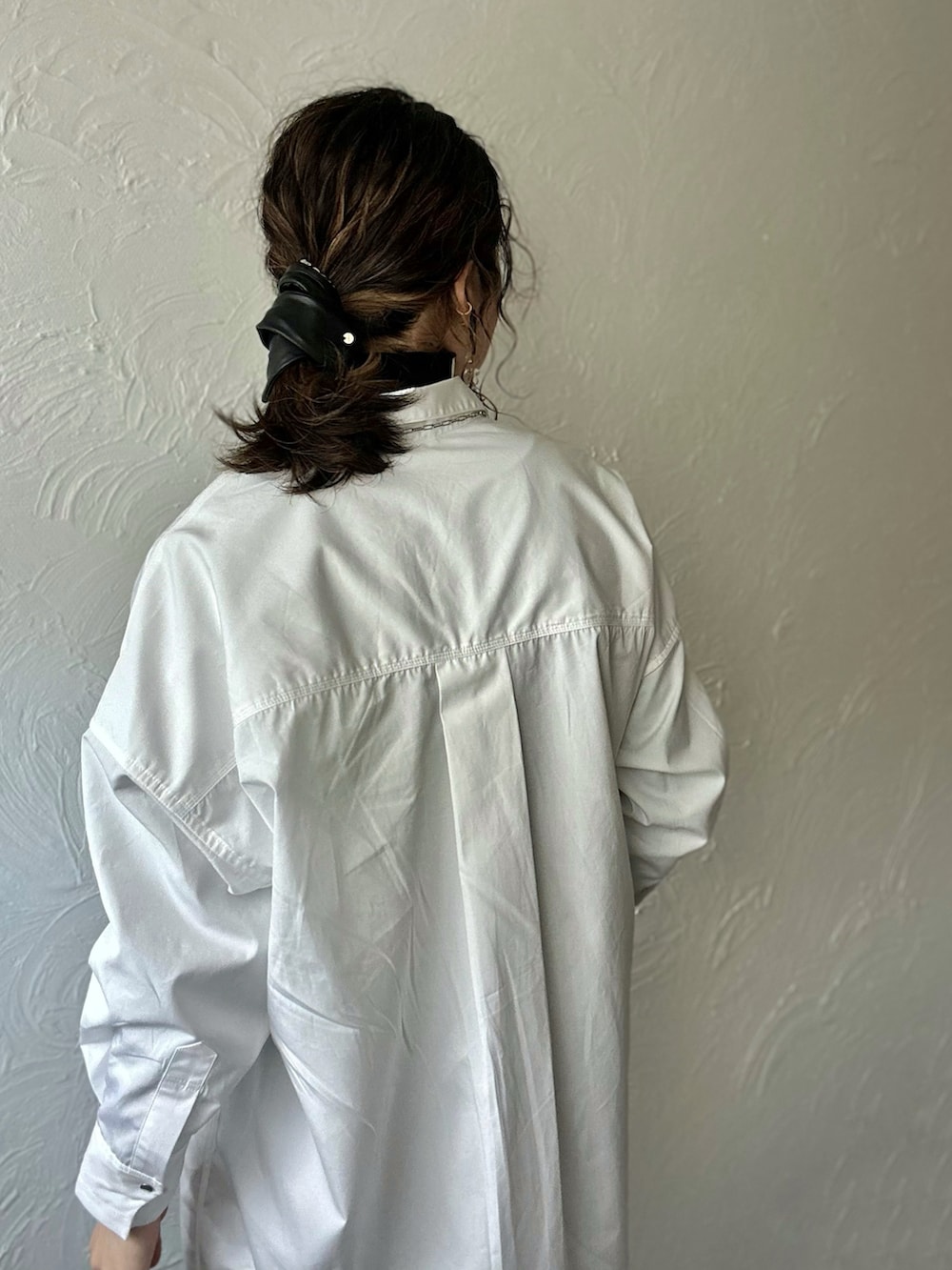 ホワイト系のシャツワンピース、ブラック系のショルダーバッグ、ブラック系のその他パンツを着用したレディースの冬コーディネートの4枚目の写真