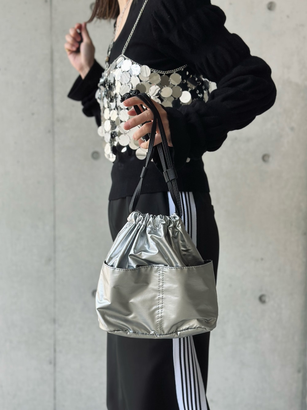 ブラック系のパンプス、シルバー系のハンドバッグ、ブラック系のスカートを着用したレディースの春コーディネートの2枚目の写真