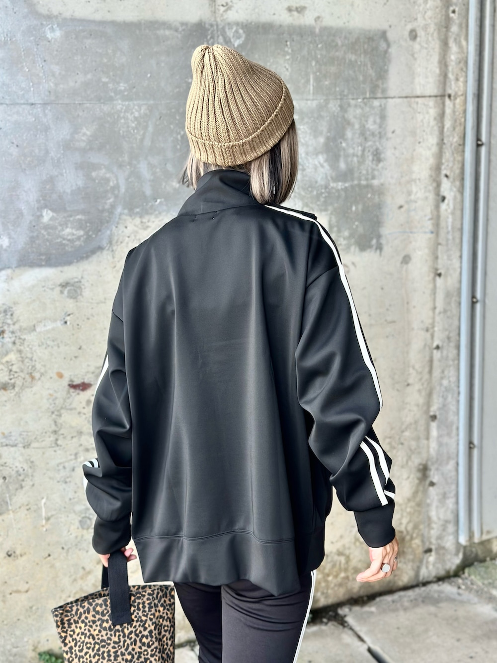 ブラック系のジャージ、ブラック系のスウェットパンツ、ベージュ系のTシャツ/カットソーを着用したレディースの夏コーディネートの5枚目の写真