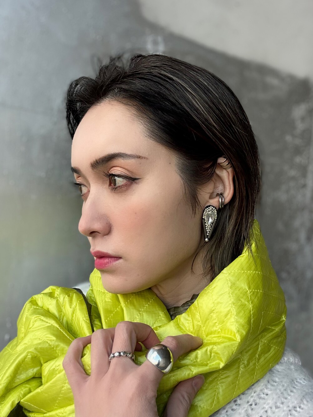 ホワイト系のカーディガン/ボレロ、イエロー系のショルダーバッグ、ホワイト系のパンプスを着用したレディースの冬コーディネートの3枚目の写真