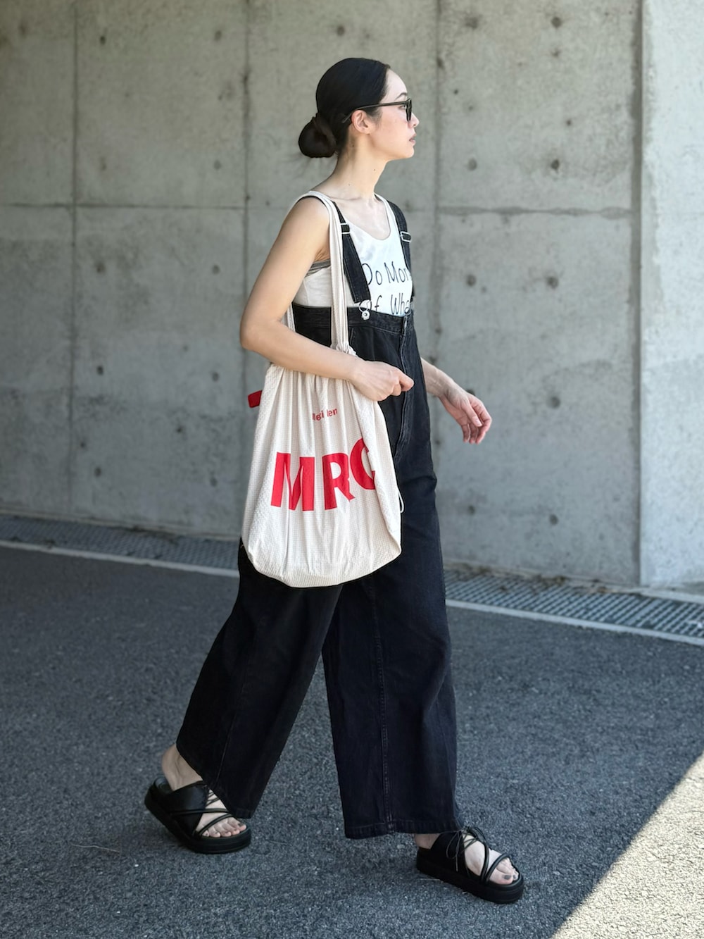 ベージュ系のトートバッグ、ブラック系のサンダルを着用したレディースの秋コーディネートの4枚目の写真