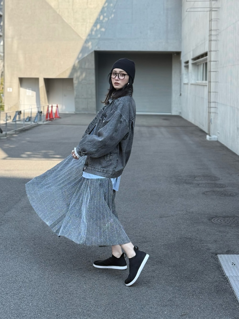 ブラック系のスニーカー、グレー系のTシャツ/カットソー、ブラック系のデニムジャケットを着用したレディースの春コーディネートの2枚目の写真