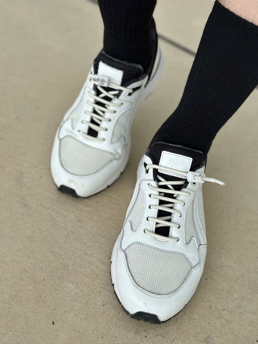 ブラック系のダウンベスト、イエロー系のスカート、ホワイト系のスニーカーを着用したレディースの冬コーディネートの5枚目の写真