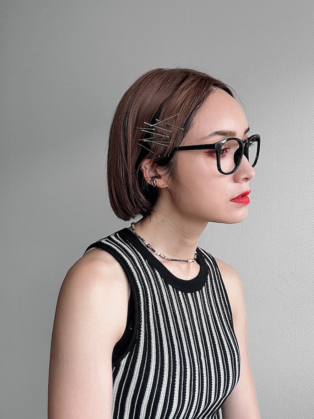 シルバー系のサンダル、ブラック系のニット/セーター、ブルー系のデニムパンツを着用したレディースの春コーディネートの4枚目の写真