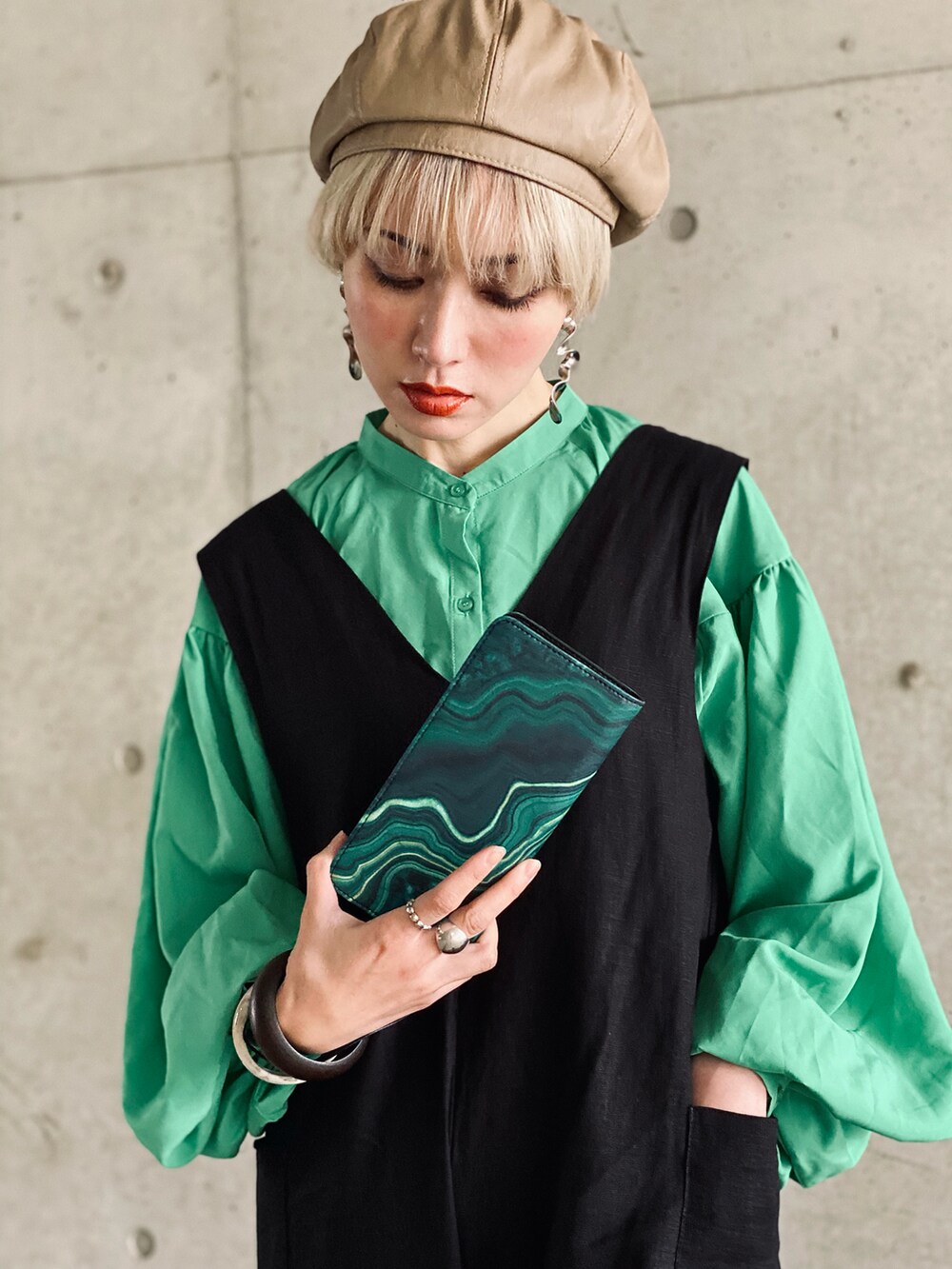 ブラック系のサロペット/オーバーオール、ベージュ系のサンダル、グリーン系のシャツ/ブラウスを着用したレディースの春コーディネートの2枚目の写真