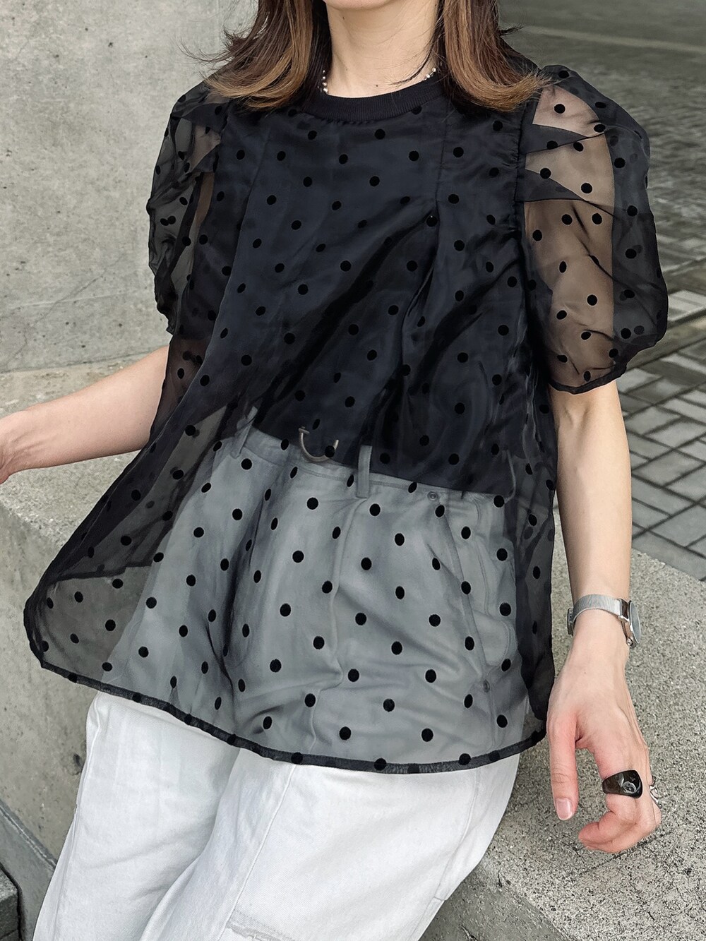 ブラック系のチューブトップ、ブルー系のデニムパンツ、ブラック系のサンダルを着用したレディースの春コーディネートの2枚目の写真