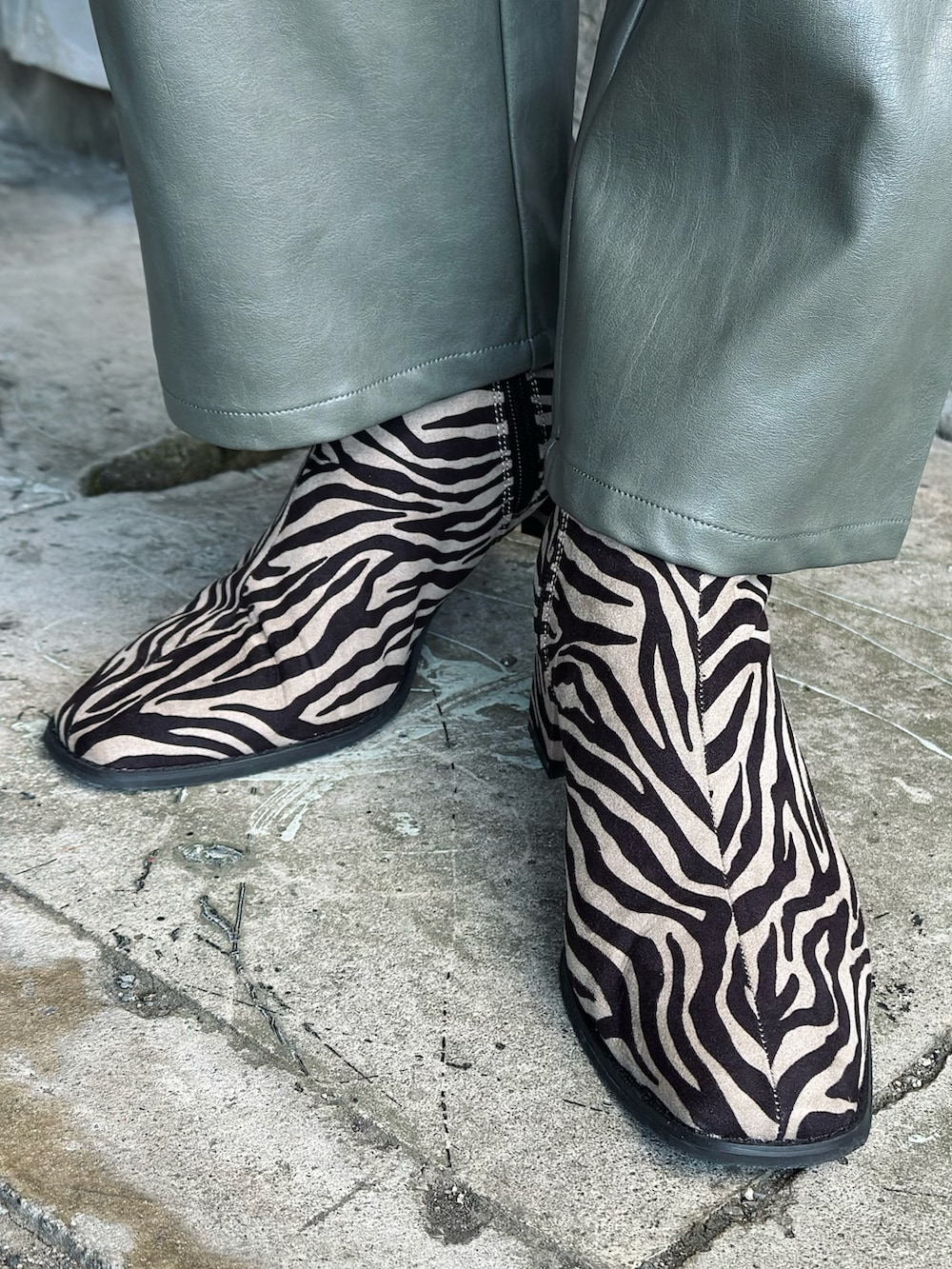 ブラック系のベスト、グリーン系のその他パンツ、その他のブーツを着用したレディースの冬コーディネートの5枚目の写真