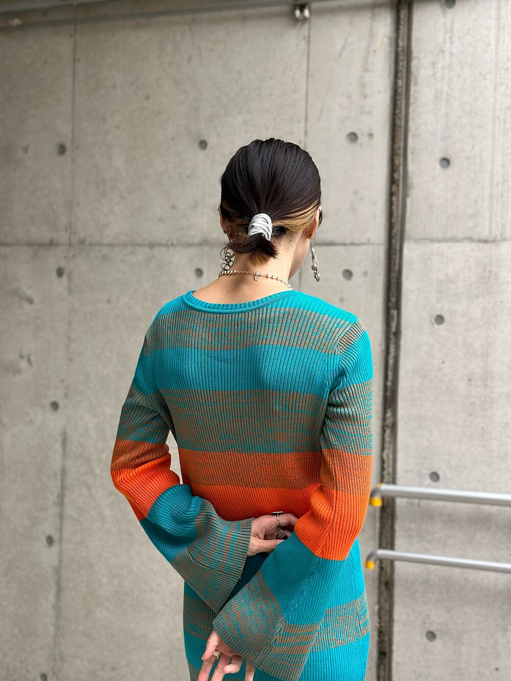 ブルー系のワンピース、ホワイト系のダウンベスト、ベージュ系のブーツを着用したレディースの秋コーディネートの5枚目の写真