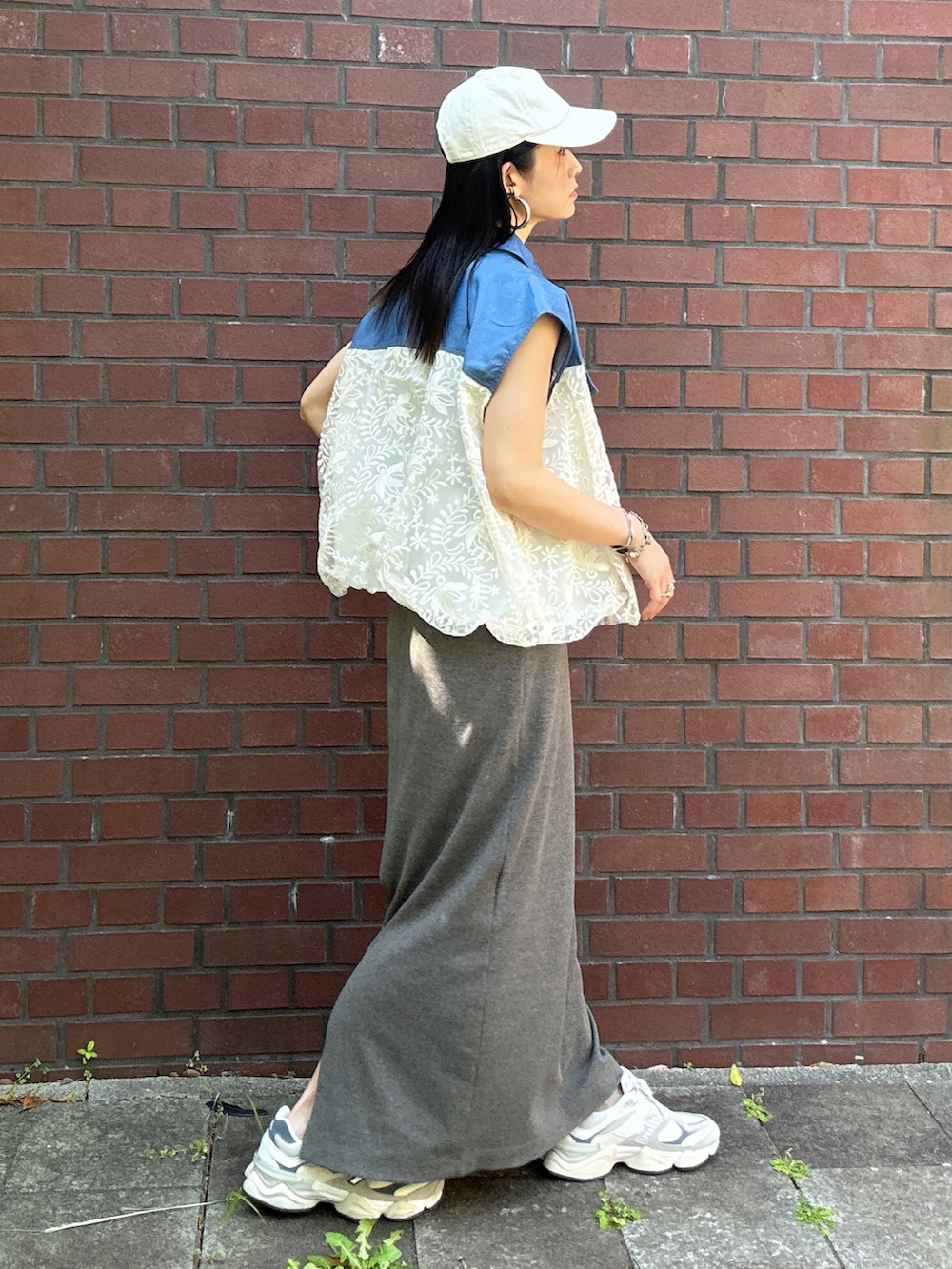 ホワイト系のブルゾン、グレー系のワンピース、ベージュ系のスニーカーを着用したレディースの夏コーディネートの3枚目の写真