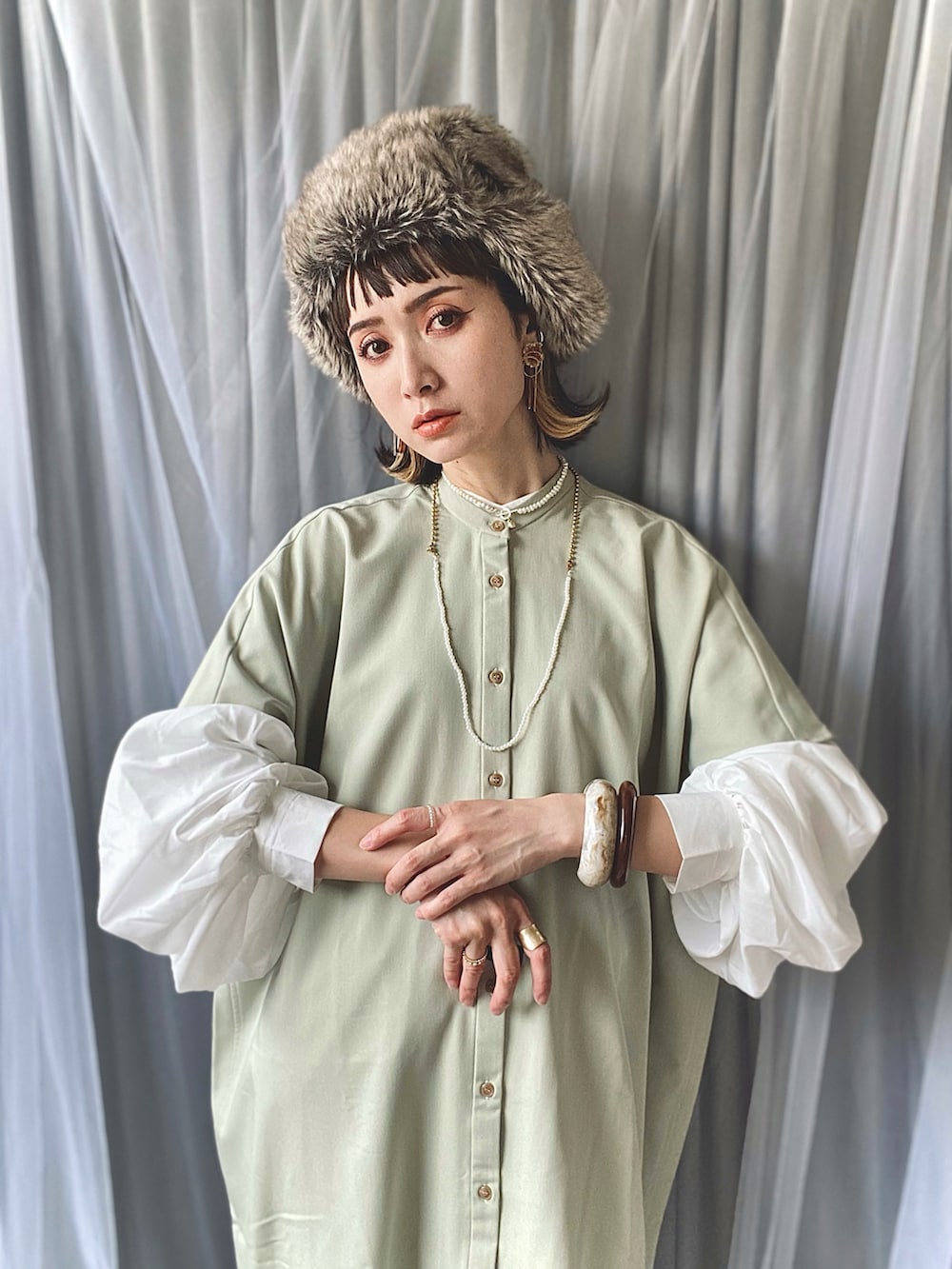 グリーン系のワンピース、ホワイト系のシャツ/ブラウス、その他のハンドバッグを着用したレディースの春コーディネートの3枚目の写真