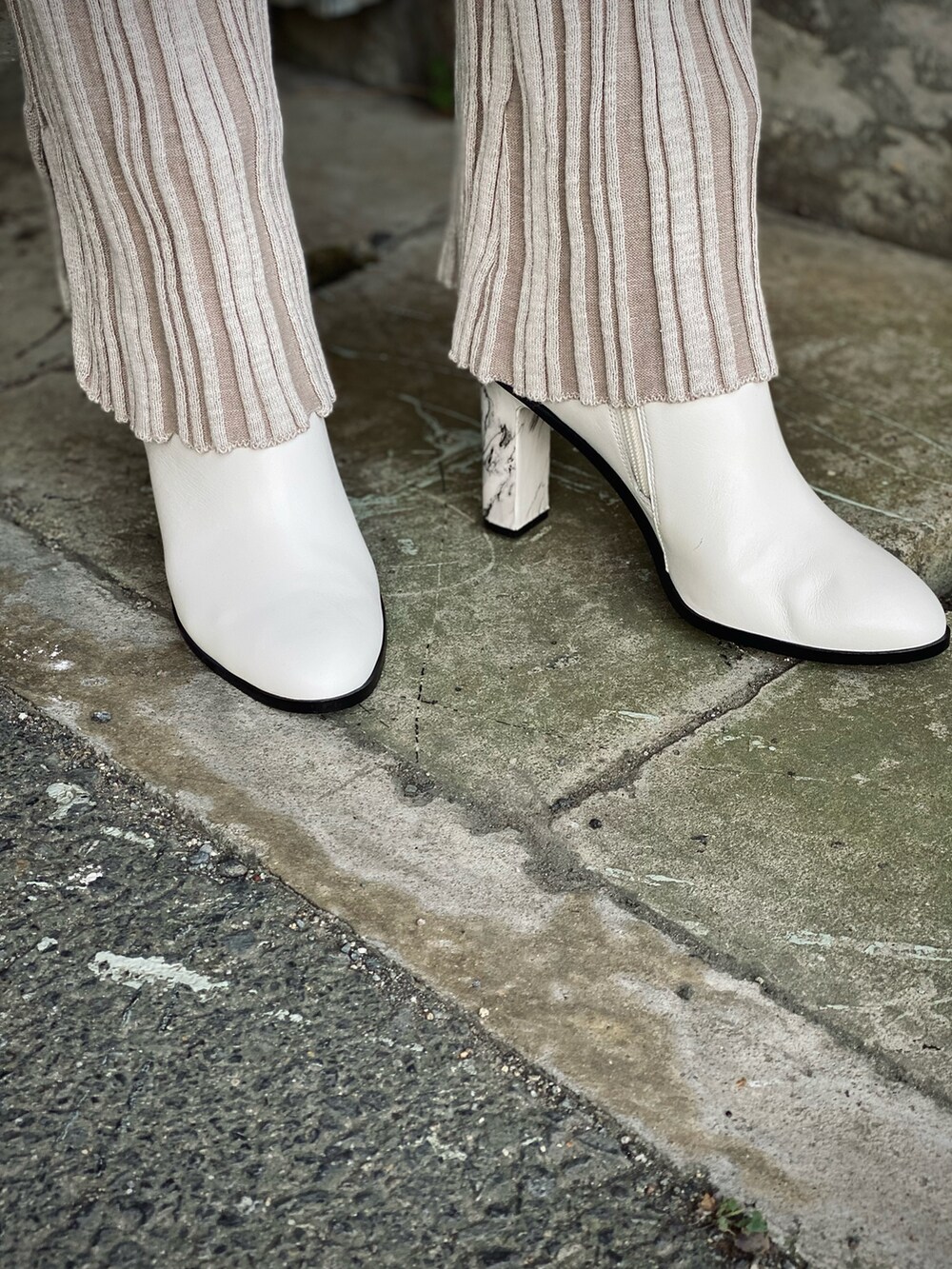 ベージュ系のその他アウター、グリーン系のニット/セーター、ホワイト系のブーツを着用したレディースの冬コーディネートの5枚目の写真