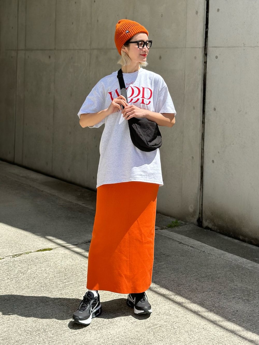 ベージュ系のTシャツ/カットソー、ホワイト系のチノパンツ、ブラック系のトートバッグを着用したレディースの春コーディネートの3枚目の写真