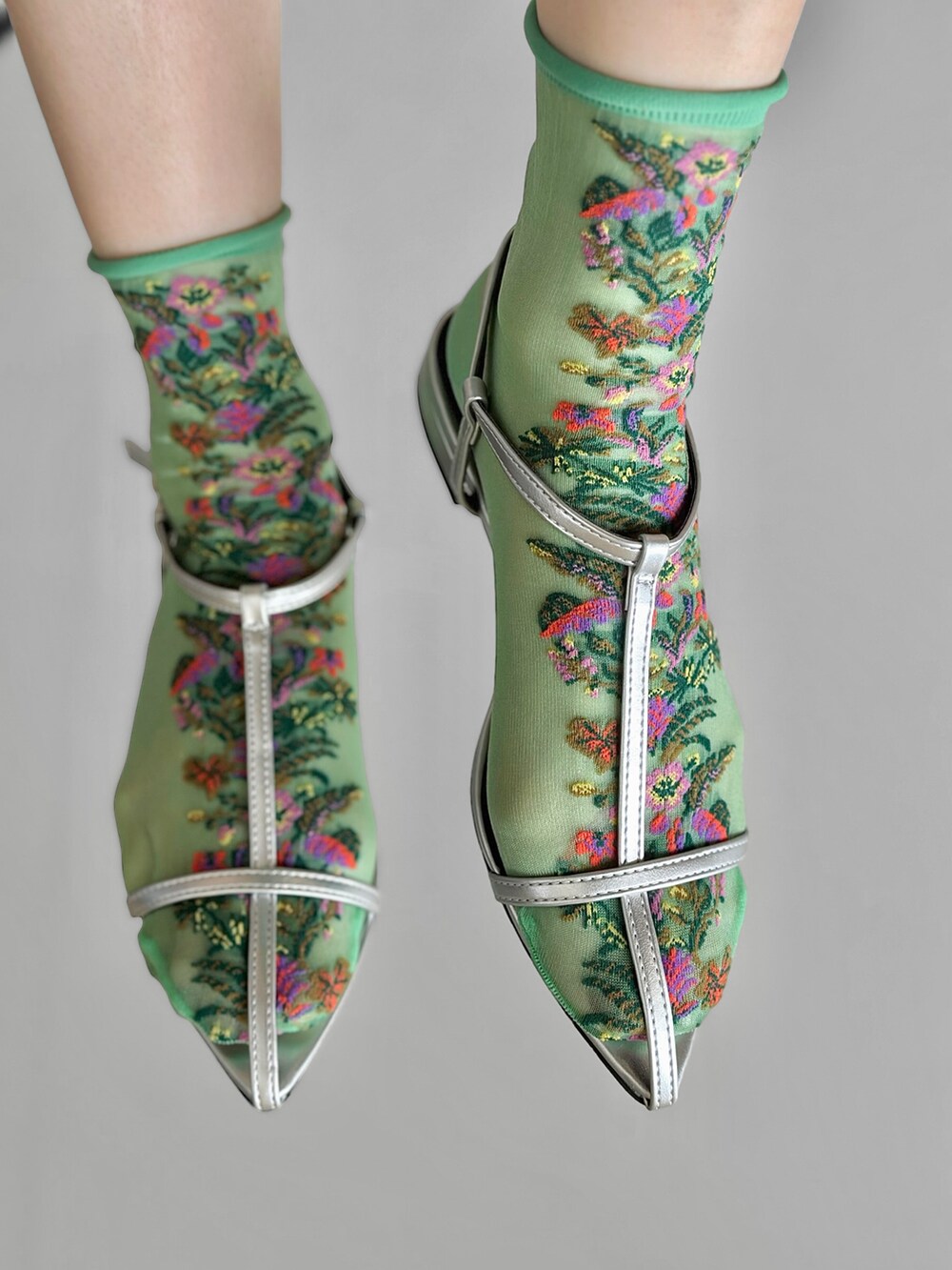 シルバー系のサンダル、ブラック系のニット/セーター、ブルー系のデニムパンツを着用したレディースの春コーディネートの2枚目の写真