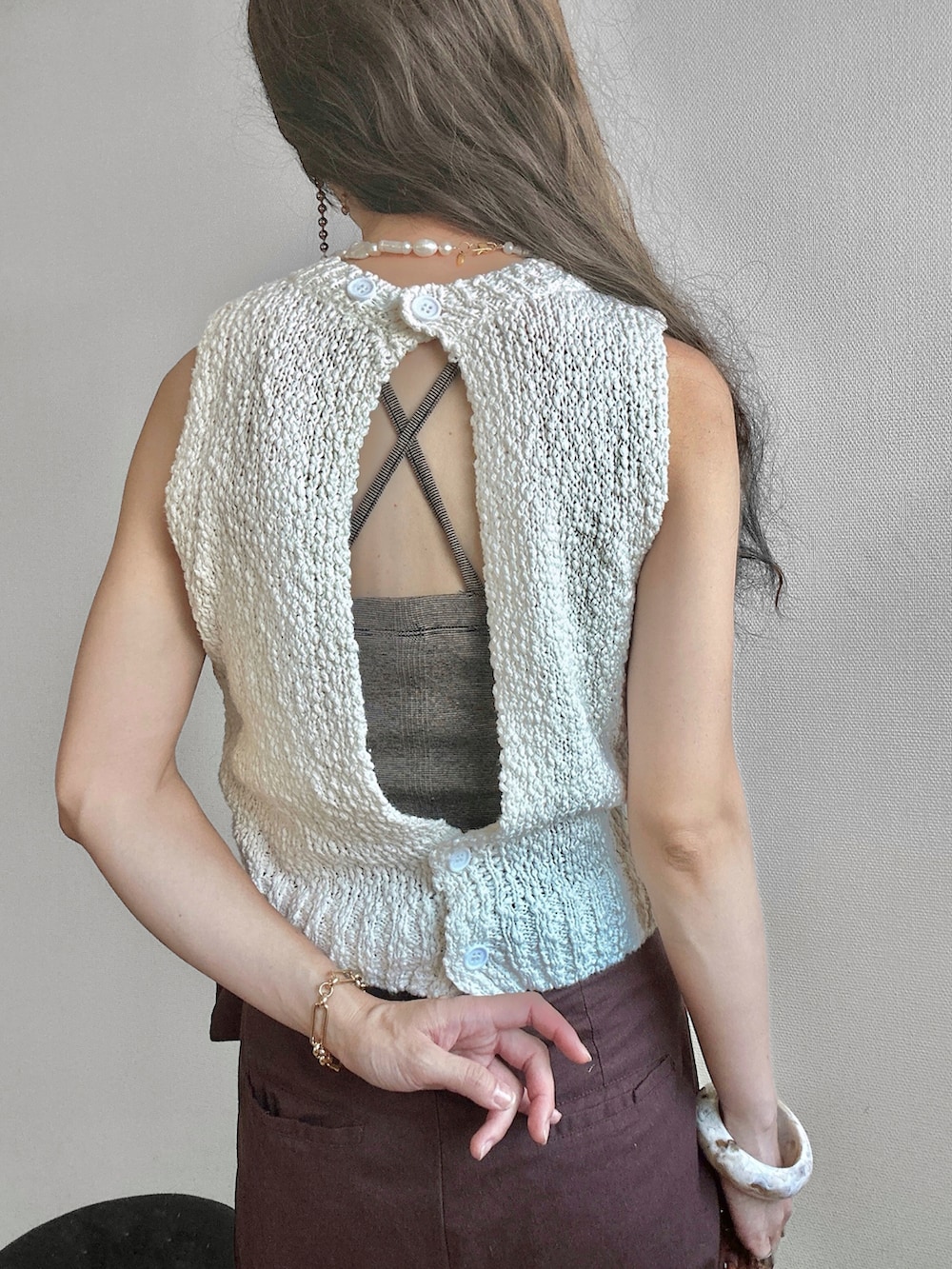 ホワイト系のベスト、ブラウン系のその他パンツ、ブラウン系のショルダーバッグを着用したレディースの夏コーディネートの3枚目の写真