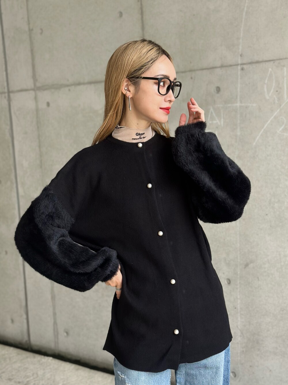 ブラック系のカーディガン/ボレロ、ブルー系のデニムパンツ、レッド系のパンプスを着用したレディースの春コーディネートの2枚目の写真